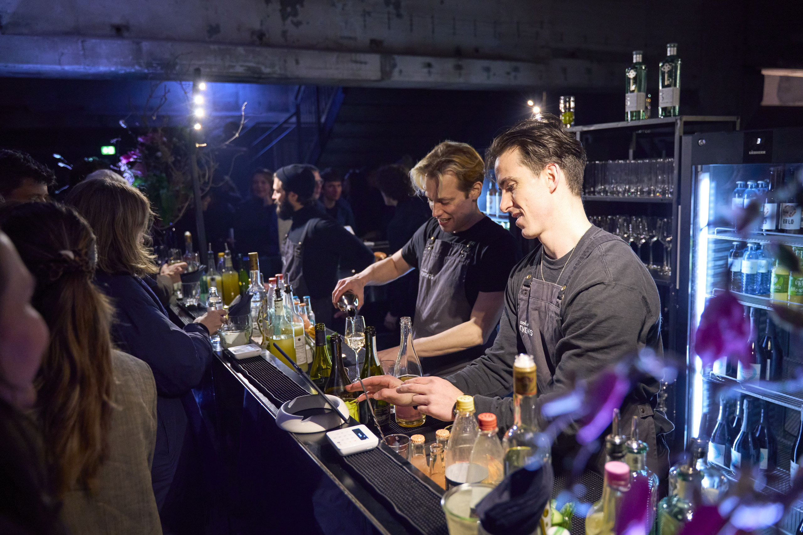 The bar crew behind the bar in blue light