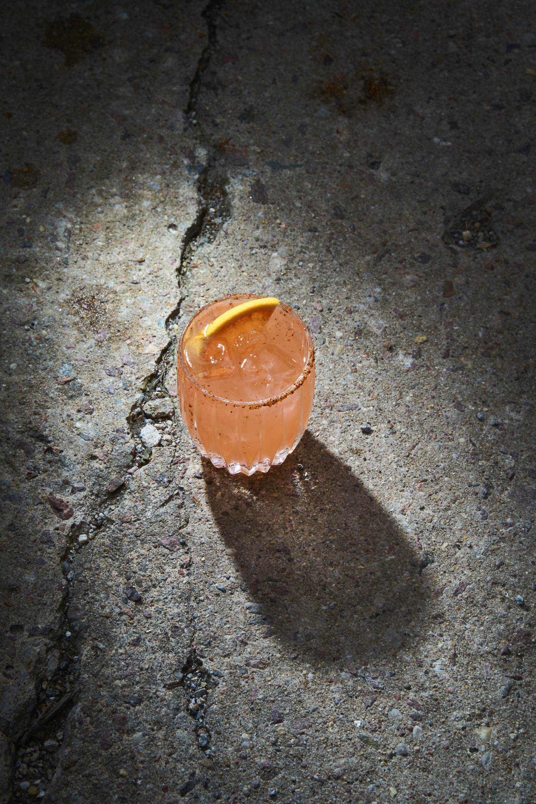 A cocktail on cracked concrete in the sun